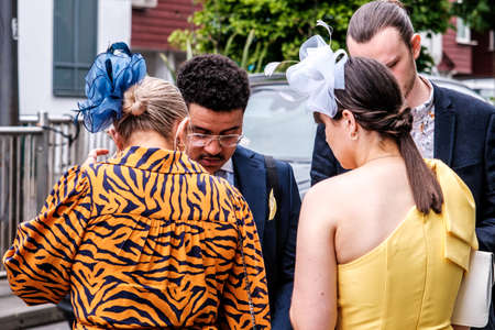 Epsom Surrey, London UK, June 04 2022, Woman Wearing Bright Tiger Print Dress And Blue Headwear Fascinatorのeditorial素材