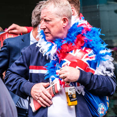 Epsom Surrey, London UK, June 04 2022, Senior Man With Patriotic Union Flas Bowler Hat Holding Bottle Of Beerのeditorial素材