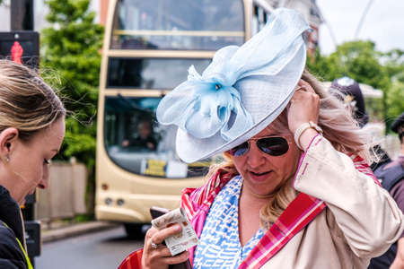 Epsom Surrey, London UK, June 04 2022, Woman Wearing A Turquiose Blue Fascinator Hat Buying A Ticketのeditorial素材
