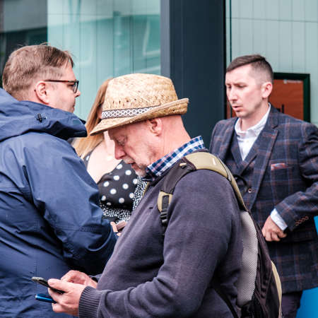 Epsom Surrey, London UK, June 04 2022, Man Wearing Straw Hat Using Mobile Phoneのeditorial素材