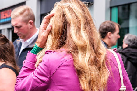 Epsom Surrey, London UK, June 04 2022, Woman With Long Blonde Hair Against A Pink Jacket Walking In A Crowdのeditorial素材
