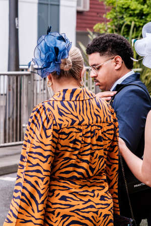 Epsom Surrey, London UK, June 04 2022, Woman Wearing Bright Tiger Print Dress And Blue Headwear Fascinatorのeditorial素材