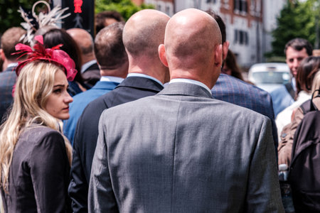 Epsom Surrey, London UK, June 04 2022, Young Woman With Red Fascinator Looking At Two Tall Bald Men On Crowded Streetのeditorial素材