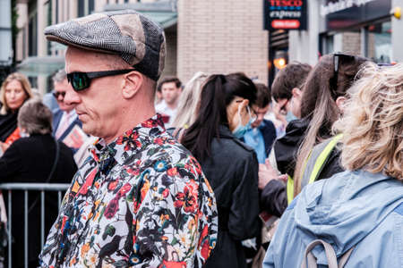 Epsom Surrey, London UK, June 04 2022, Man Wearing Flat Cap And Colourful Patterned Shirt With Sunglasses On Crowded Streetのeditorial素材