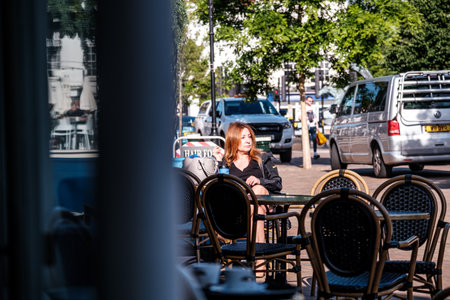 Epsom Surrey, London, June 11 2022, Woman With Red Hair Sitting Alone Outside Cafe Nero Relaxingのeditorial素材