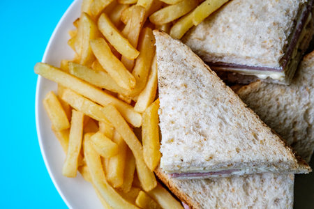 London UK, July 14 2025, Homemade Ham and Cheese Sandwich In Sliced Brown Bread With Chips Or Fries