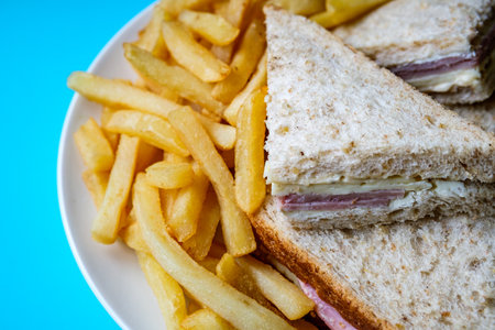 London UK, July 14 2025, Homemade Ham and Cheese Sandwich In Sliced Brown Bread With Chips Or Fries
