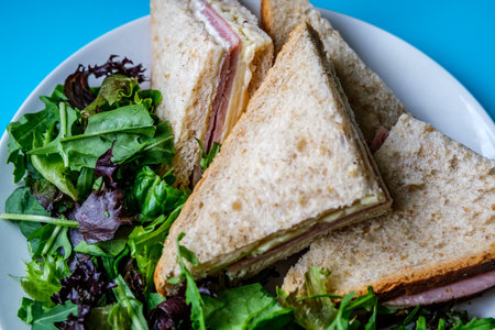 London UK, July 14 2025, Homemade Ham and Cheese Sandwich In Sliced Brown Bread With Green Salad...