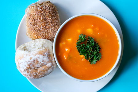 London UK, July 16 2025, A Bowl Of Healthy Vegetable Soup Garnished With Parsley And Soft Bread...