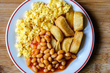 London UK June 25 2025, Scrambles Eggs With Baked Beans In Tomato Sauce And Thick Cut Fried Chips