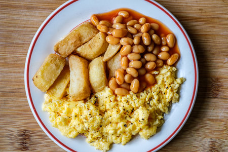 London UK June 25 2025, Scrambles Eggs With Baked Beans In Tomato Sauce And Thick Cut Fried Chips