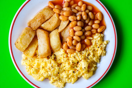 London UK June 25 2025, Scrambles Eggs With Baked Beans In Tomato Sauce And Thick Cut Fried Chipsの写真素材