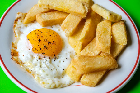 London UK June 25 2025,  Fried Egg Sunny Side Up With Thick Cut Chuncky Chipsの写真素材