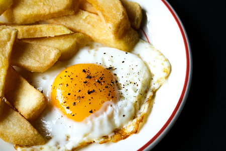 London UK June 25 2025,  Fried Egg Sunny Side Up With Thick Cut Chuncky Chips