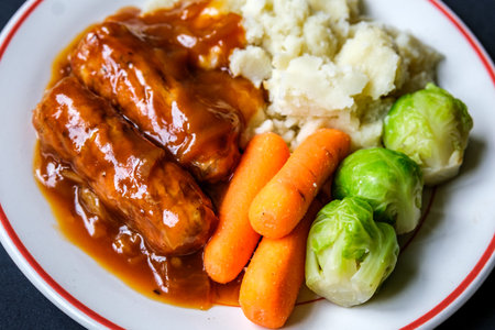 London UK, June 24 2025, Classic Bangers And Mash With Carrots and Brussel Sprouts Vegetablesの写真素材