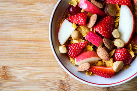 London UK, June 20 2025, Bowl Of Corn Flakes Breakfast Cereal With Fresh Fruit And Mixed Nutsの写真素材