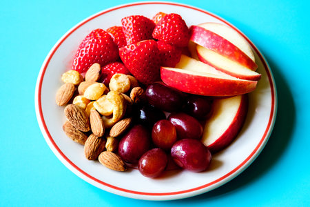 London UK, June 20 2025, A Plate Of Healthy Fresh Summer Fruit And Mixed Nutsの写真素材