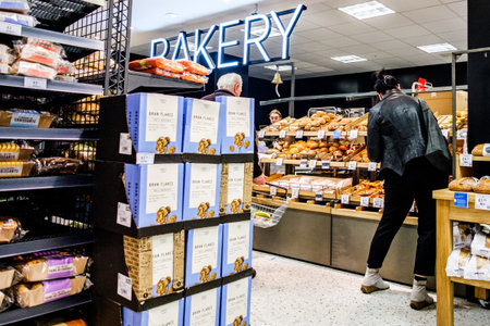 London UK March 18 2026, Woman Standing at Supermarket Bakery Counter Browsing Fresh Pastries