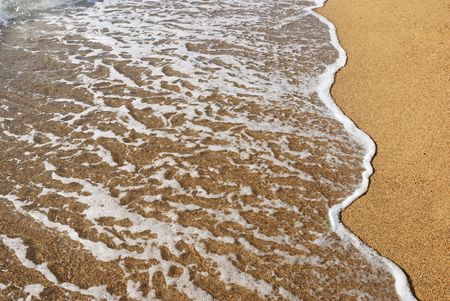 sea wave on a wet sandの写真素材