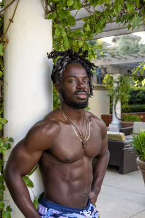 Handsome young muscular African American man posing shirtless outside.の写真素材