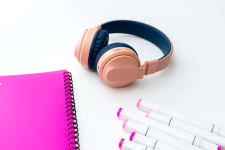 top view of the desktop. professional multi-colored markers, pink folder, headphonesの写真素材