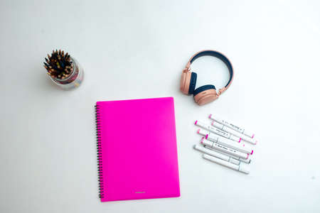 top view of the desktop. professional multi-colored markers, pink folder, headphonesの写真素材