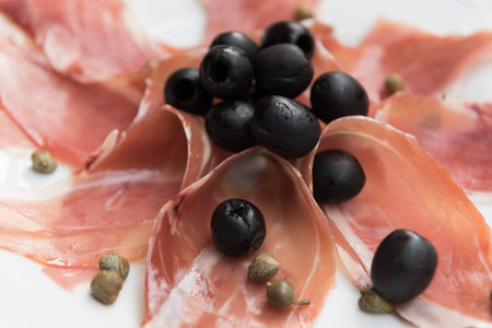 Appetizer of olives, capers and serrano hamの写真素材