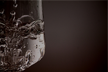 Splashing water in the glass, without a shadow in the backgroundの写真素材
