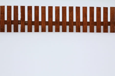 brown boards fence in snow landの写真素材