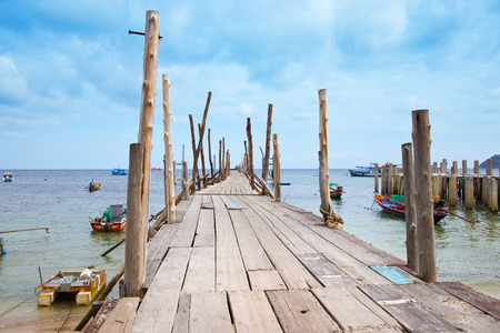 old wooden pier and many fisherman boatsの写真素材