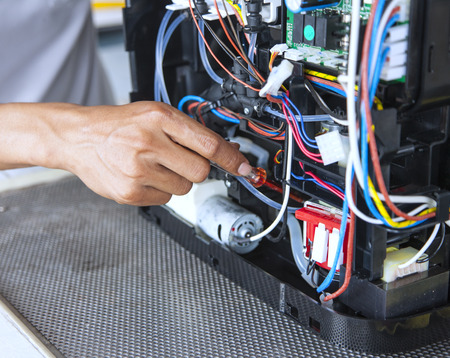 mans hand fixing abstract electronic deviceの写真素材