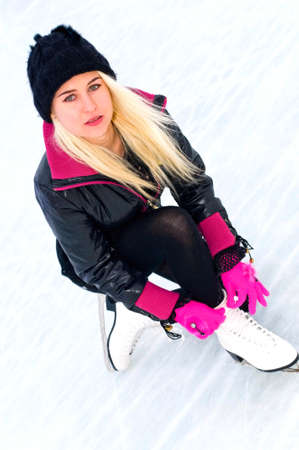young blonde woman in skates on iceの写真素材