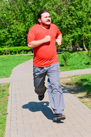 smiling man running in the parkの写真素材