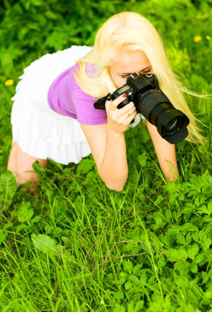 blonde young woman with cameraの写真素材