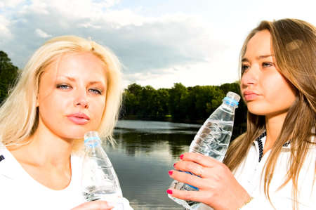 two girls drinking waterの写真素材