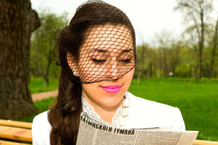 portrait of young woman with newspaperの写真素材