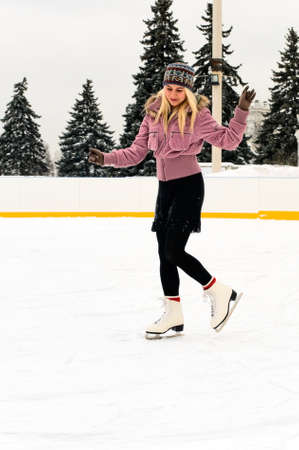 pretty young blonde woman skating on iceの写真素材