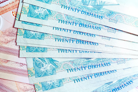 A high-quality, top-down view of United Arab Emirates currency (AED), featuring a mix of colorful...