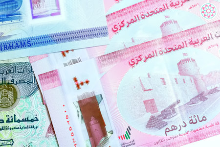 A high-quality, top-down view of United Arab Emirates currency (AED), featuring a mix of colorful...