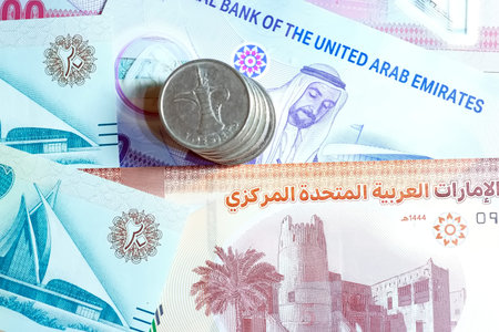 A high-quality, top-down view of United Arab Emirates currency (AED), featuring a mix of colorful...
