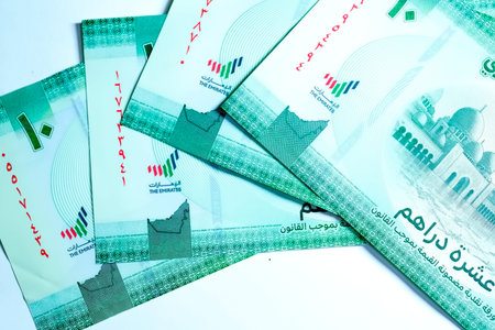 A high-quality, top-down view of United Arab Emirates currency (AED), featuring a mix of colorful...