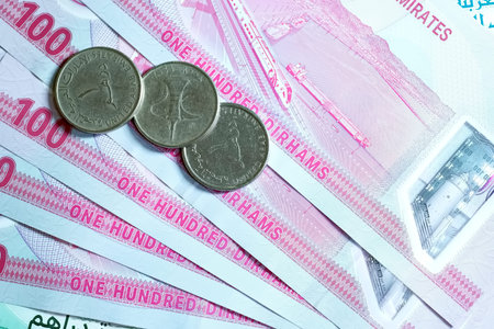 A high-quality, top-down view of United Arab Emirates currency (AED), featuring a mix of colorful...