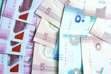 A high-quality, top-down view of United Arab Emirates currency (AED), featuring a mix of colorful...