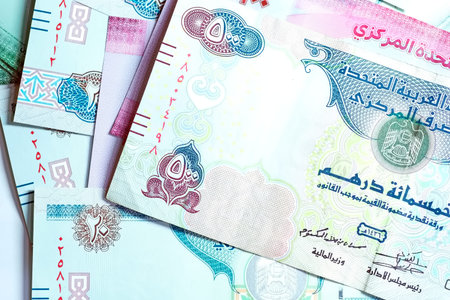 A high-quality, top-down view of United Arab Emirates currency (AED), featuring a mix of colorful...