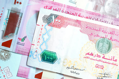 A high-quality, top-down view of United Arab Emirates currency (AED), featuring a mix of colorful...
