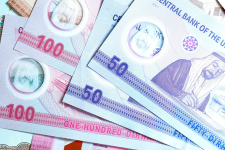 A high-quality, top-down view of United Arab Emirates currency (AED), featuring a mix of colorful...