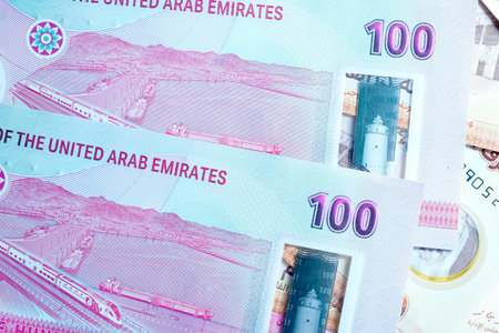 A high-quality, top-down view of United Arab Emirates currency (AED), featuring a mix of colorful...