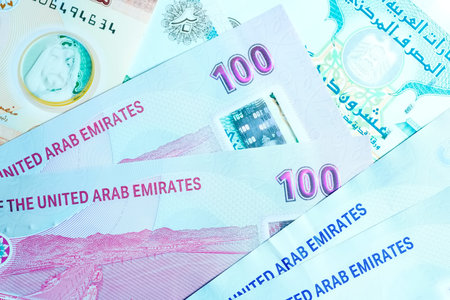 A high-quality, top-down view of United Arab Emirates currency (AED), featuring a mix of colorful...