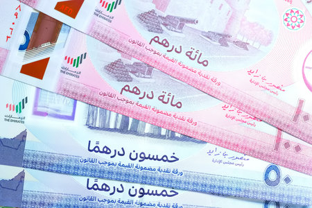 A high-quality, top-down view of United Arab Emirates currency (AED), featuring a mix of colorful...