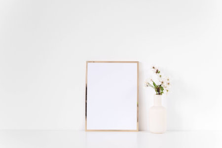 Gold frame mock up with spring feminine flowers. Mockup for your photo, design or text.の写真素材